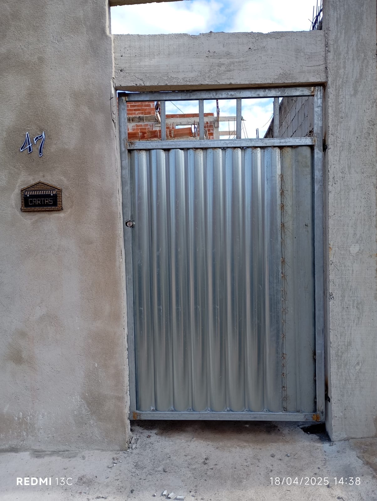 Portão social de chapa galvanizada instalado na entrada de casa